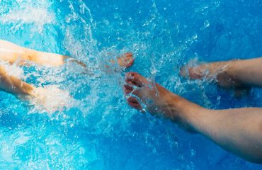 Man and woman's feet kicking and splashing in a hot tub.